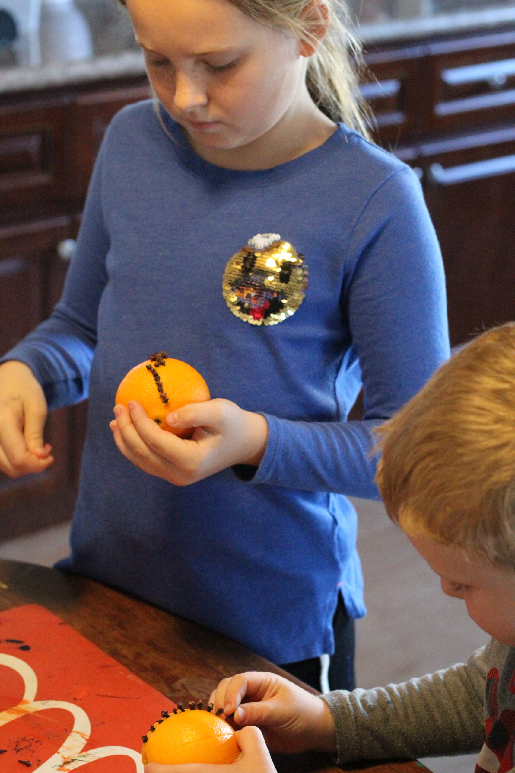 Kids putting Cloves into Oranges