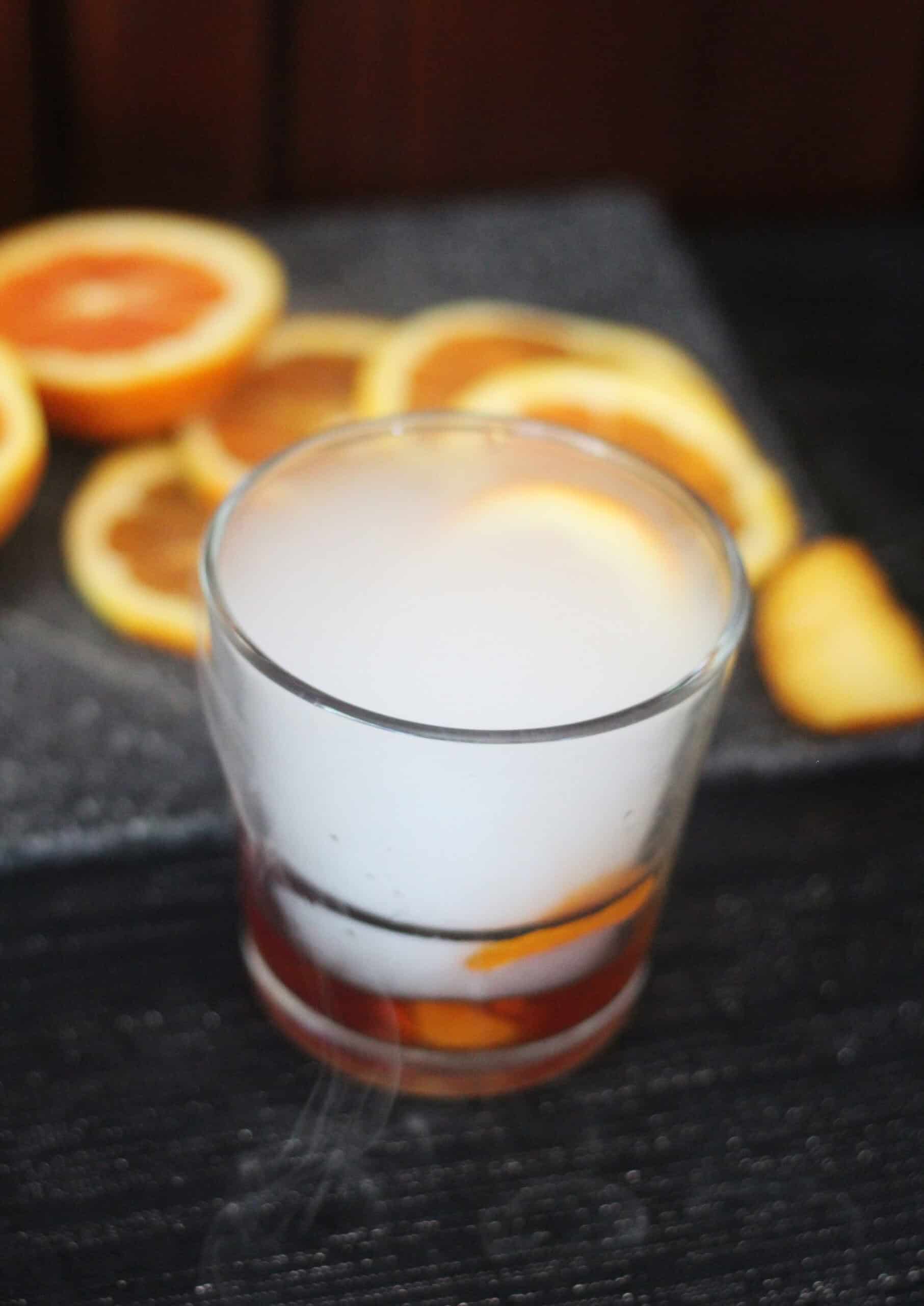 Orange slices, orange peel and an old fashioned cocktail 